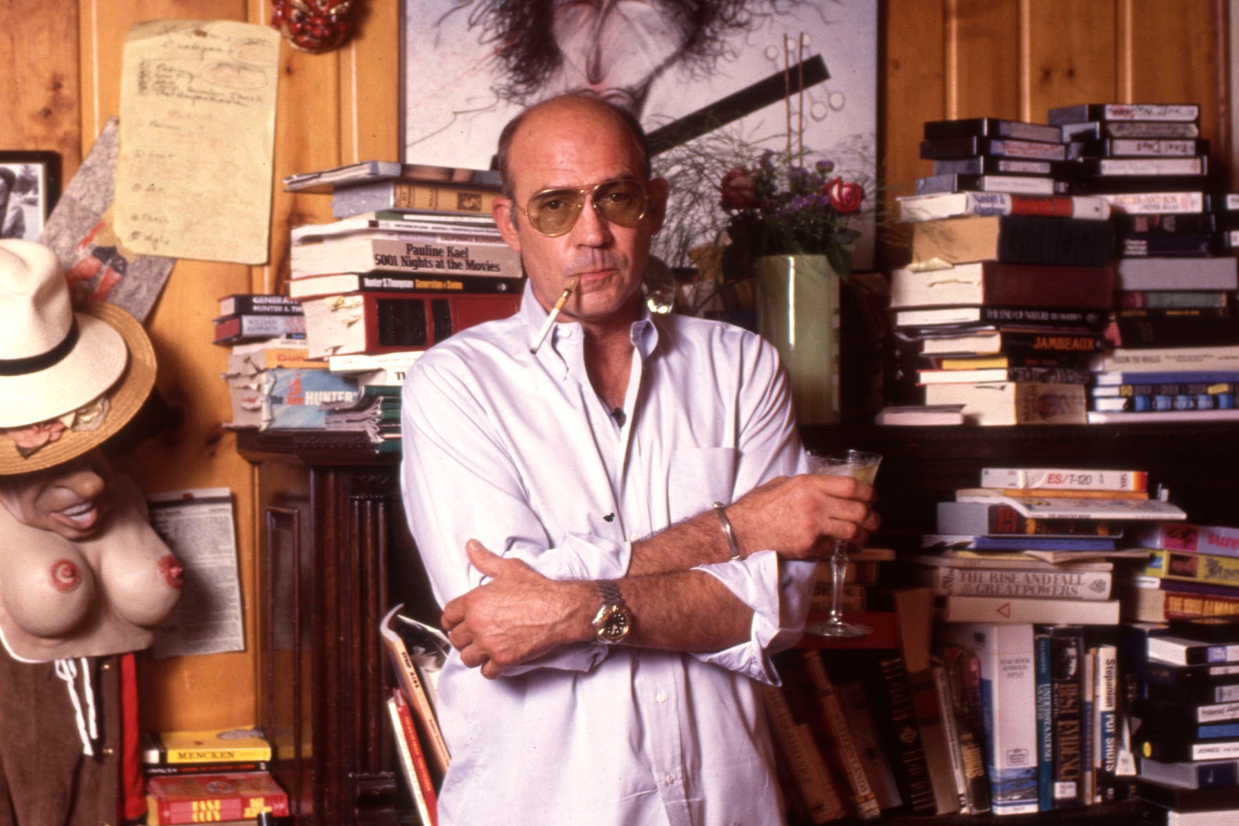 Hunter S Thompson stood against a bookshelf