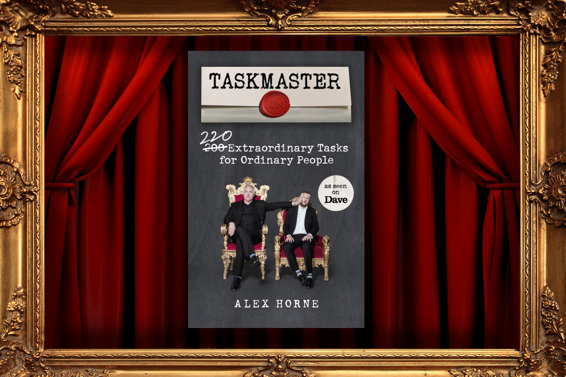 The Taskmaster book, in front of the trademark curtains of the television show.