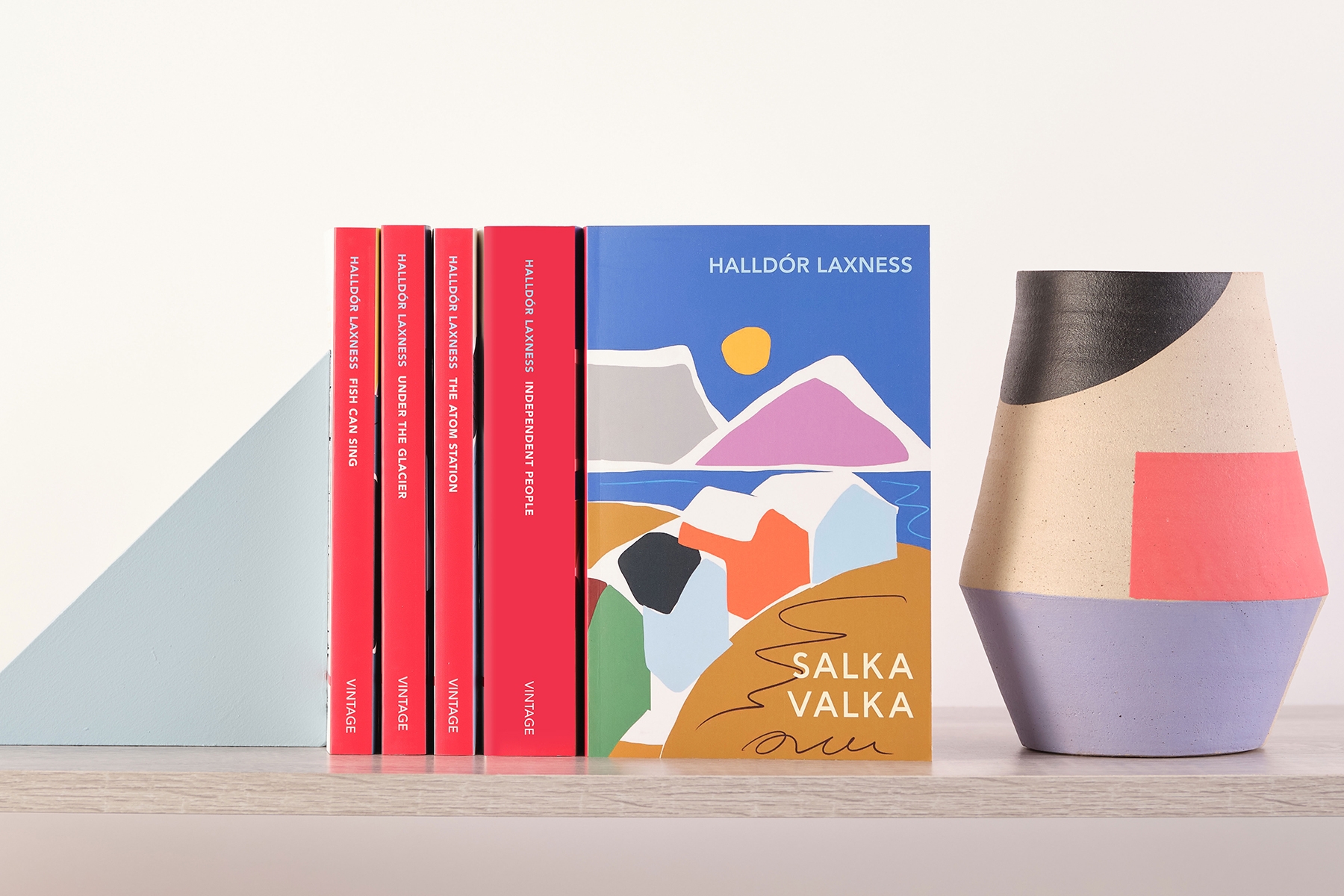 Shelf of Halldor Laxness books next to a vase, with red Vintage Classics spines showing and Salka Valka standing upright to display cover.