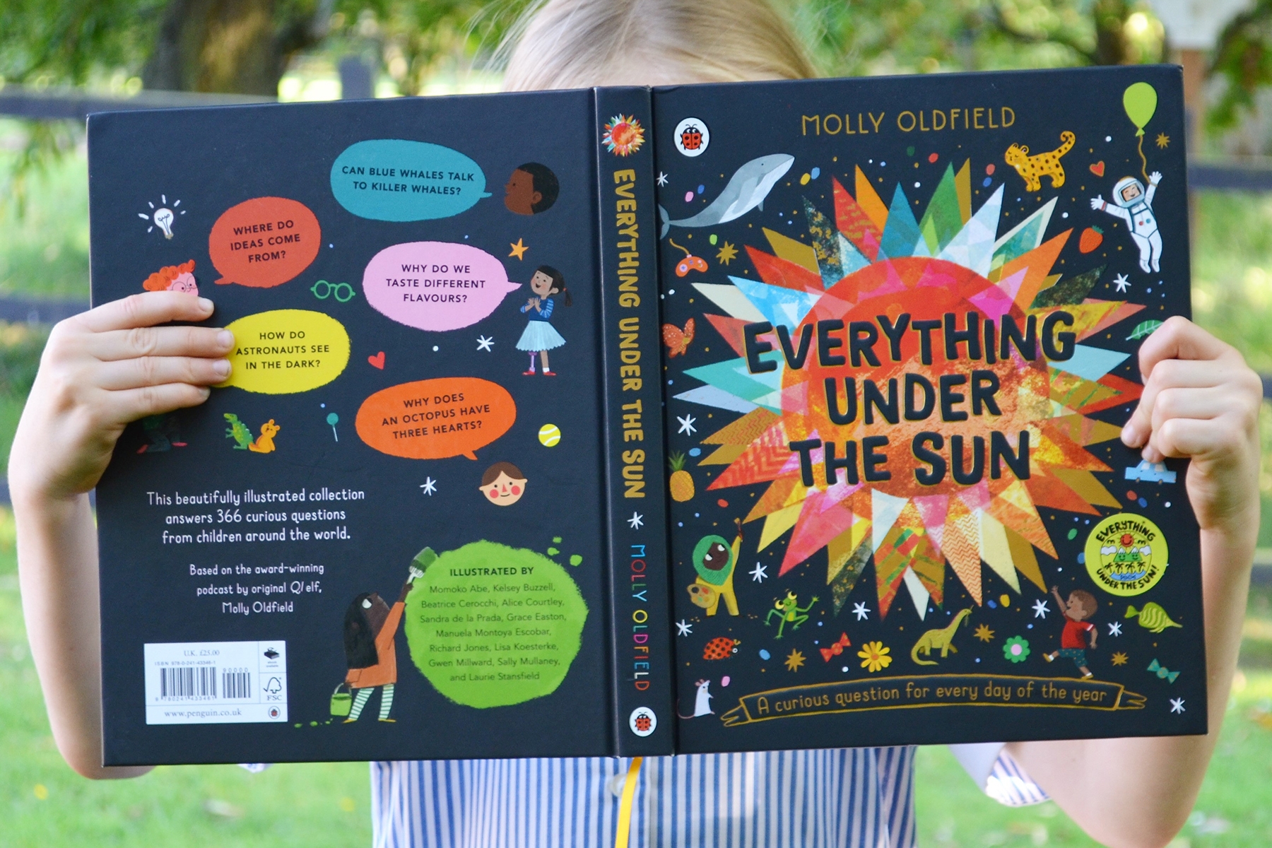 A photo of a young girl holding the book Everything Under The Sun so that it covers her face